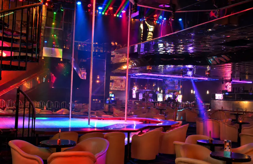 Inside the main room — stages, lounge chairs, bar, and light show at Déjà Vu Minneapolis