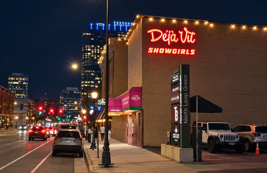 Side of the building from the sidewalk — Déjà Vu neon over the North Loop street