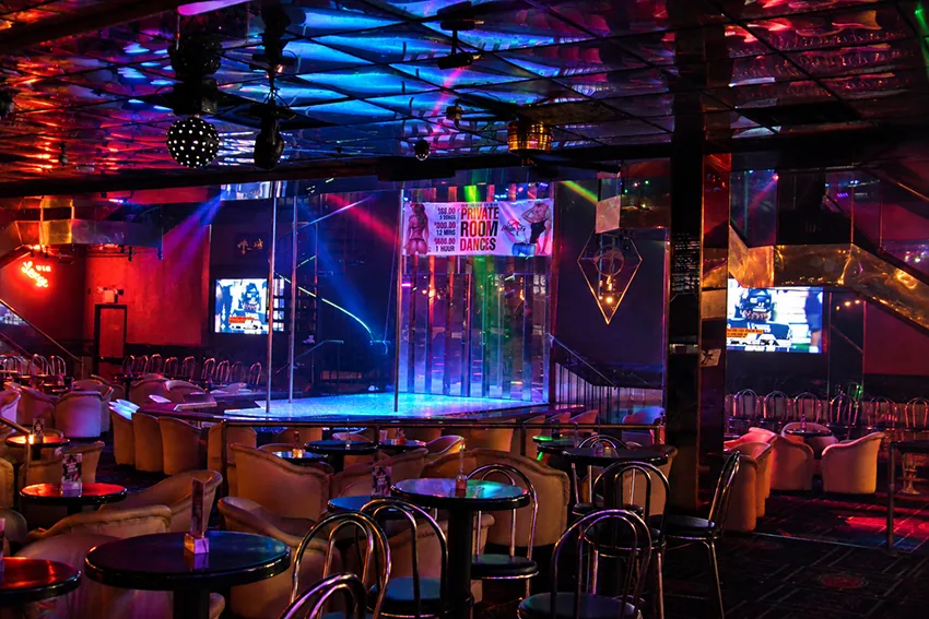 The main room at Déjà Vu Showgirls Minneapolis — center stage, mirrored ceiling, and lounge seating