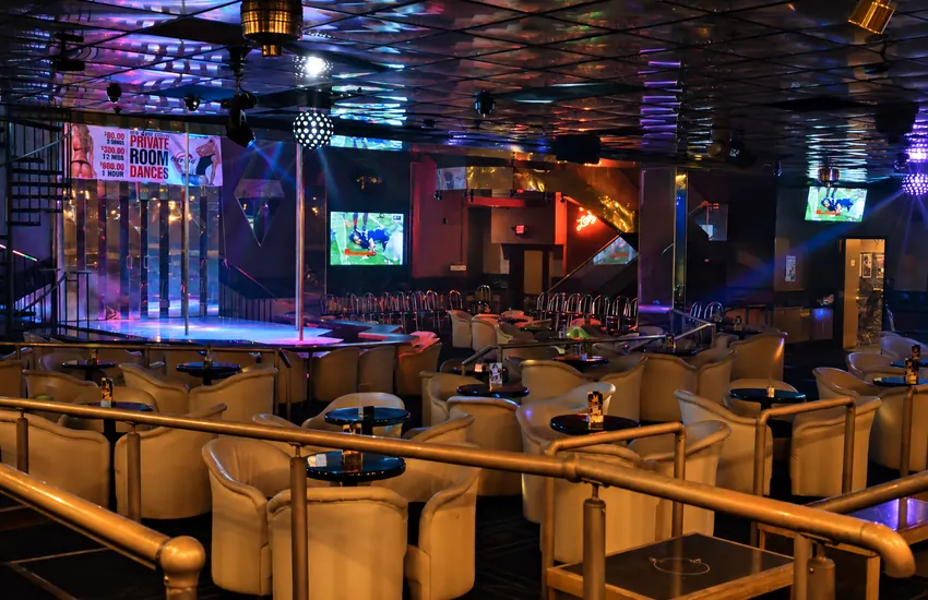 Lounge seating rows facing the stage under the mirrored ceiling