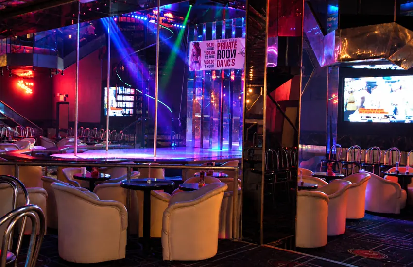 Center stage with poles and lounge seating in blue and pink light