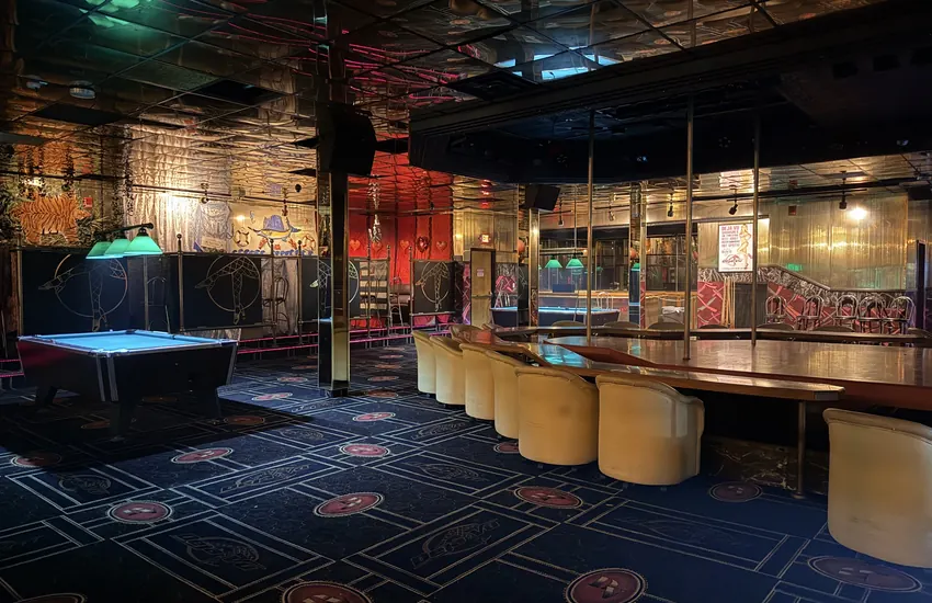 Upstairs at Déjà Vu — pool table, rail seating, and the gold mirrored ceiling