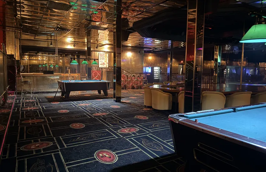 Upstairs pool tables and bar under the green lamps